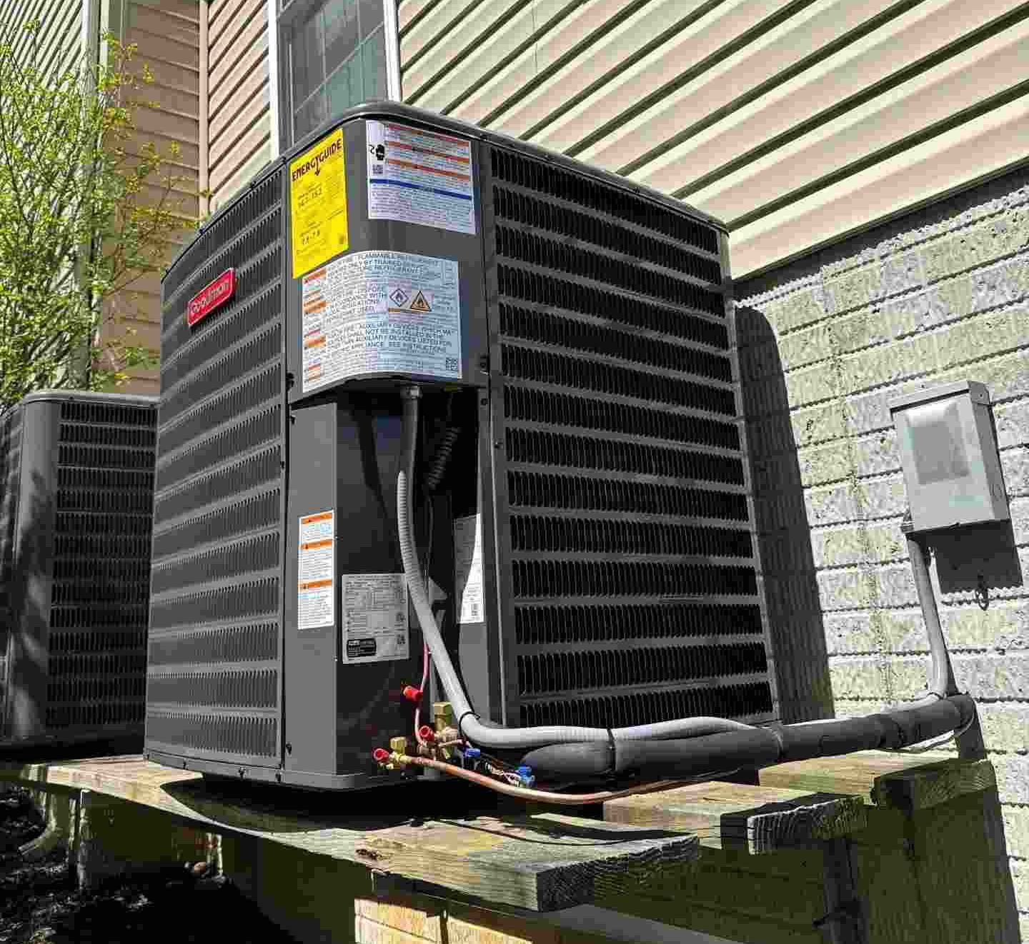HVAC technician performing summer maintenance on an air conditioning system in Baltimore.