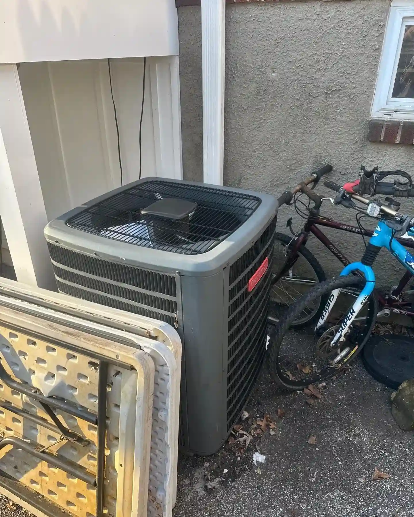Blog Technician performing HVAC maintenance on an outdoor unit in June
